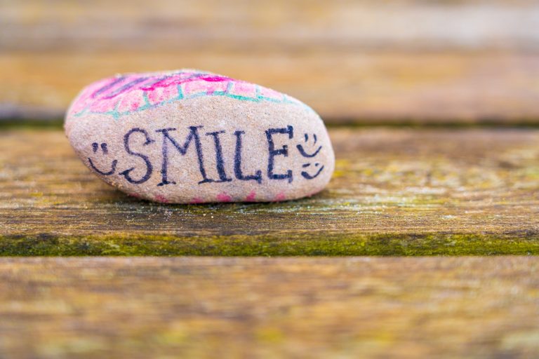 Pebble painted withe words smile